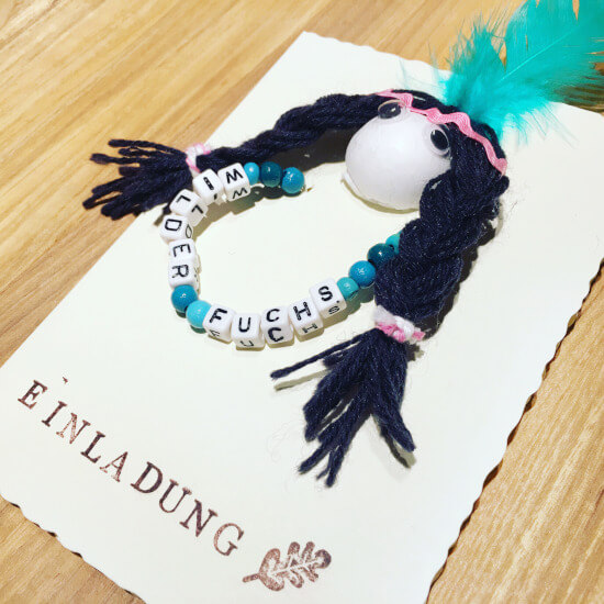 Indianerparty Einladung als Karte mit einem Indianerkopf und einem Armband