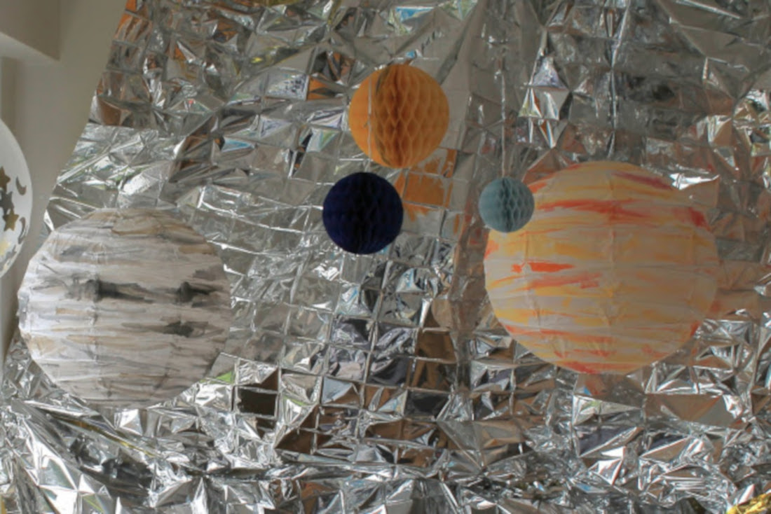 Eine metallische Rettungsdecke ist der perfekte Hintergrund für eine galaktische Fotowand