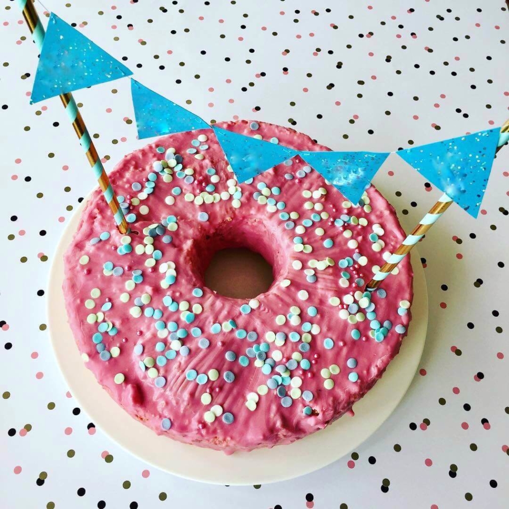 Der Konfettikuchen hat eine rosafarbene Glasur und bunte Konfettistreusel