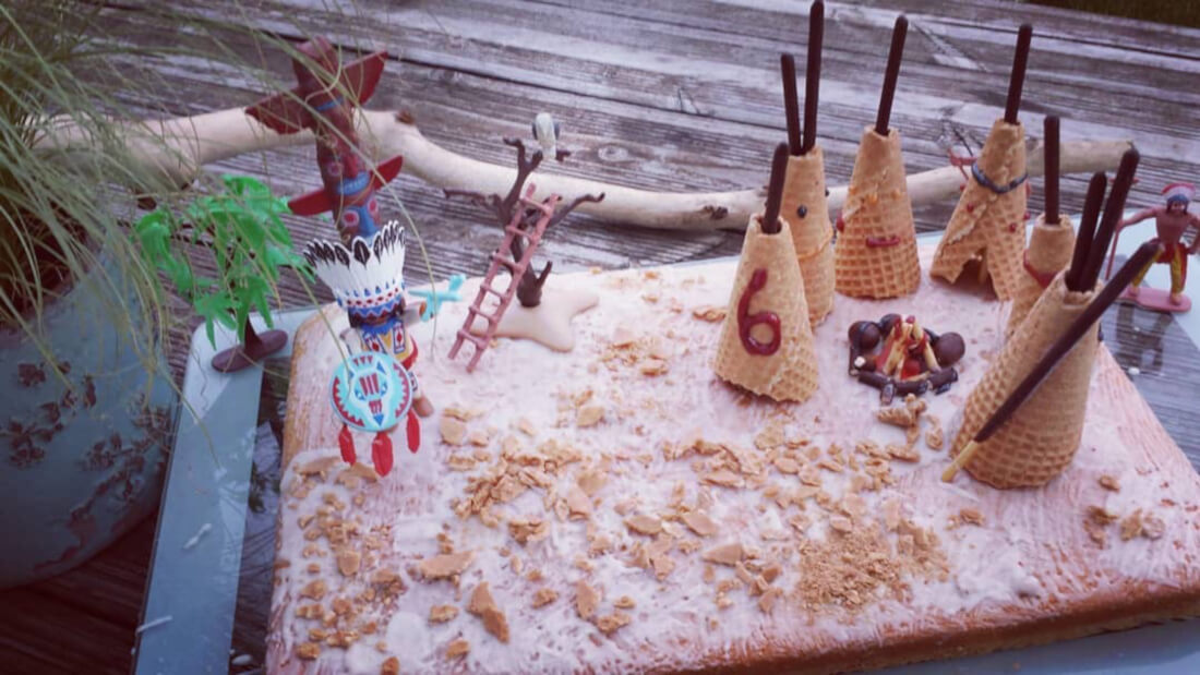 Blechkuchen mit vielen Eiswaffel-Tipis und Spielzeugfiguren als Accessoires